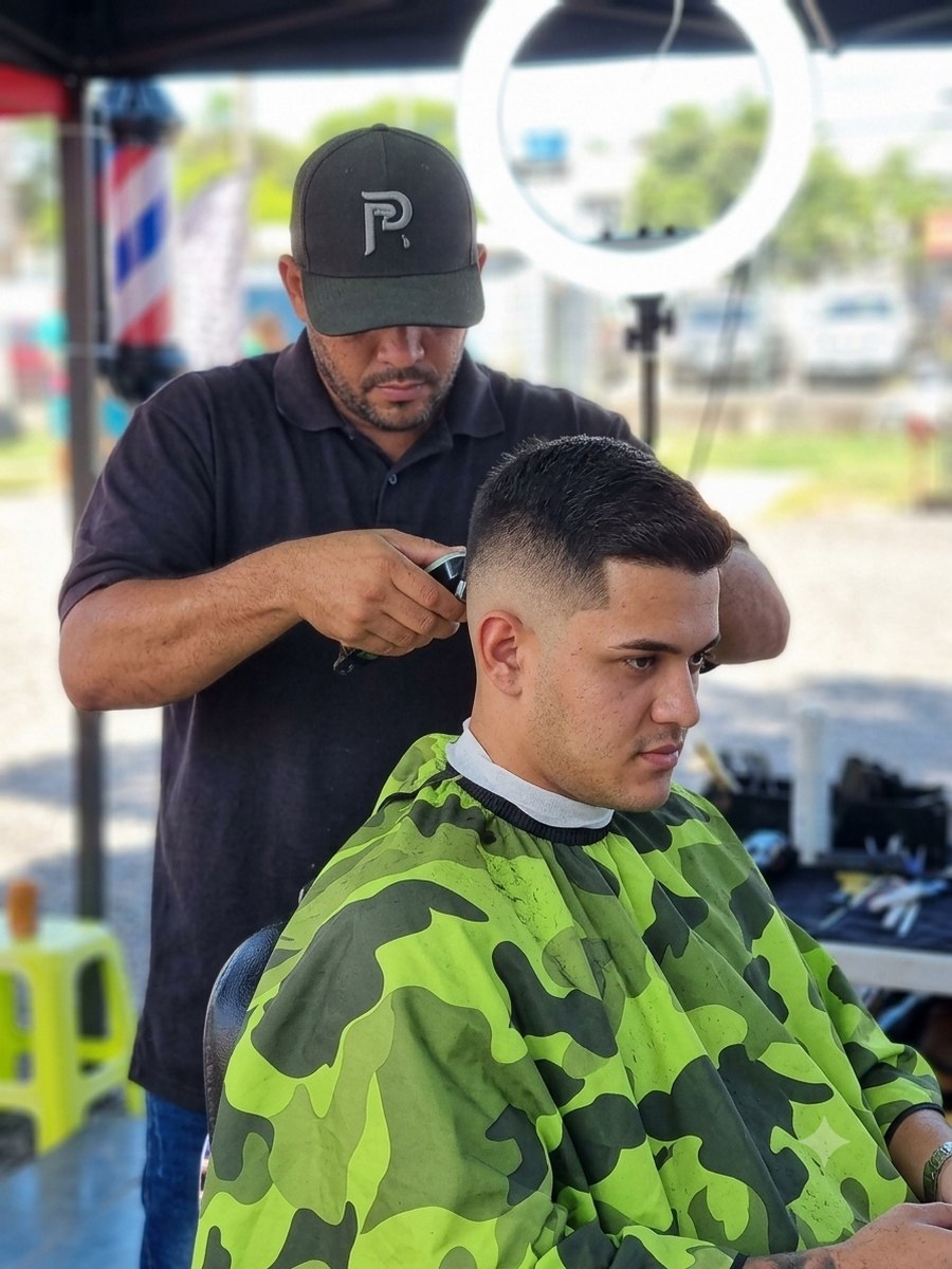 Barbier de Roots Barbers Tahiti réalisant un fade en extérieur